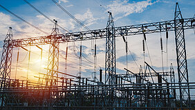 Sunset behind substation towers with blue sky