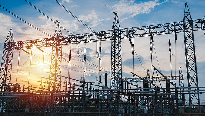 Sunset behind substation towers with blue sky