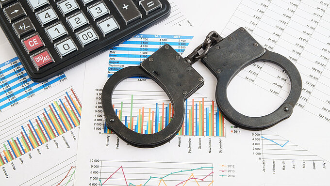 Financial fraud concept, calculator and handcuffs on financial documents