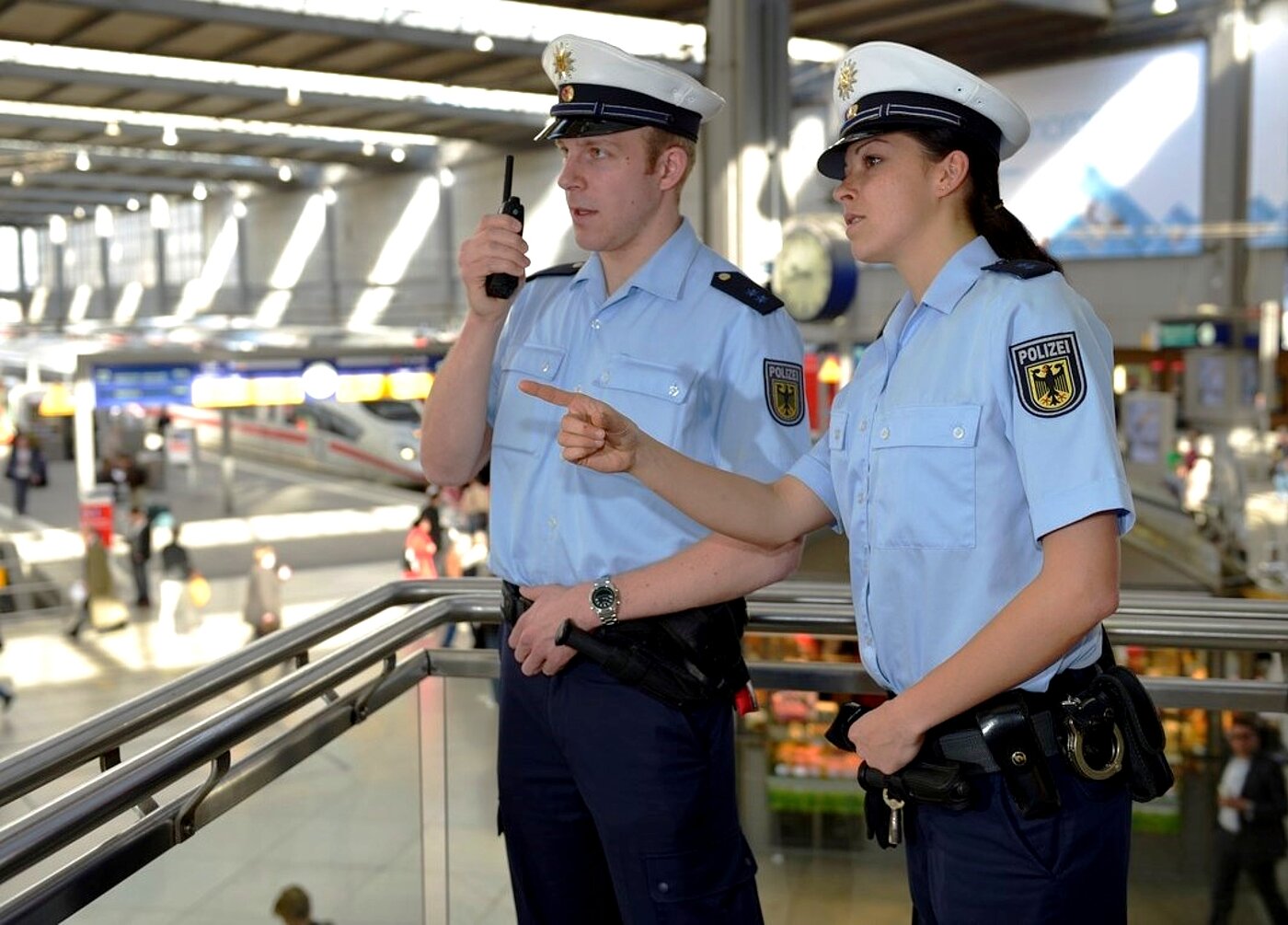 Mann und Frau im Bahnhof Blick in eine Richtung Fingerzeig