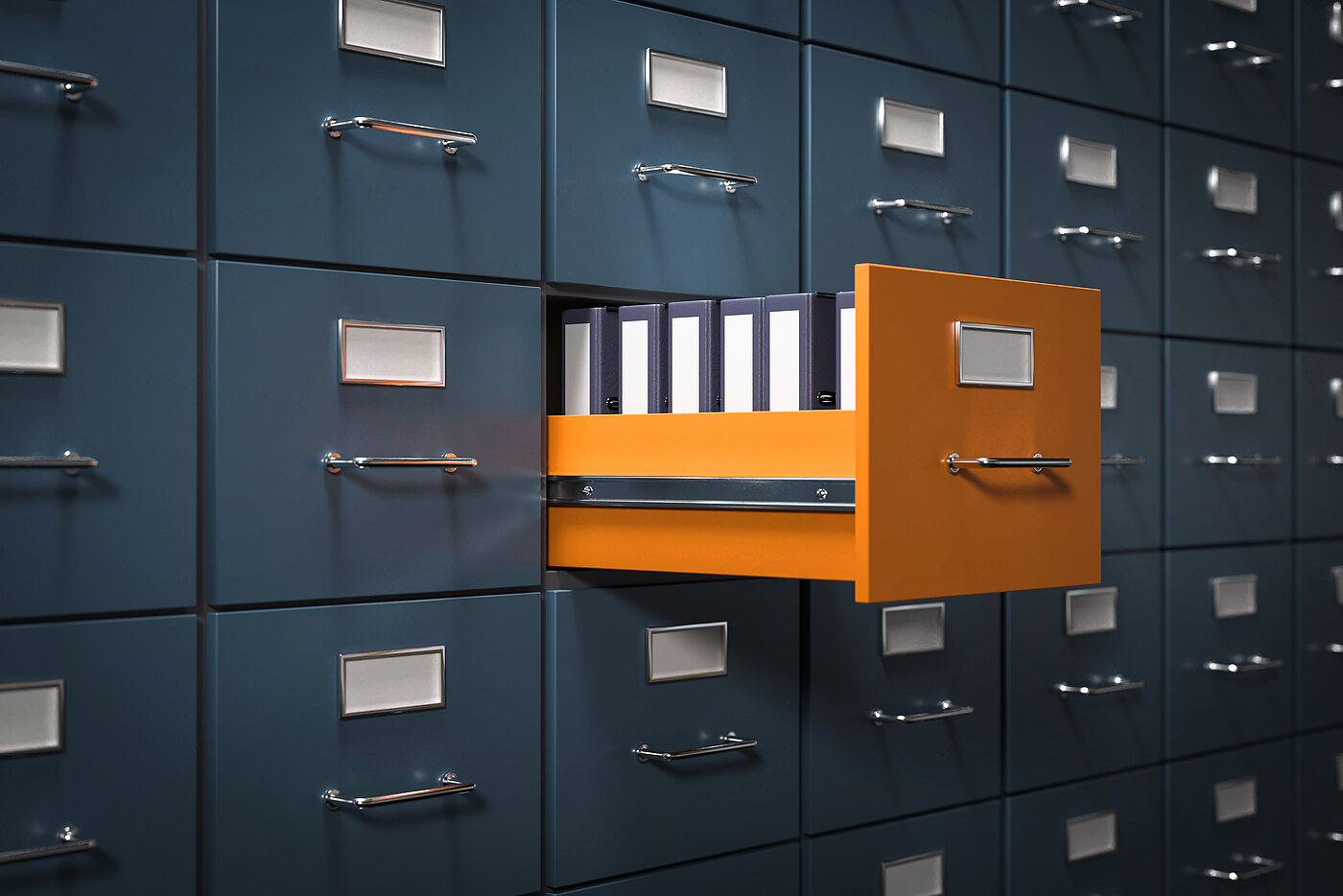 Aktenschrank dunkelblau und eine mittige Schublade in orange ist auf