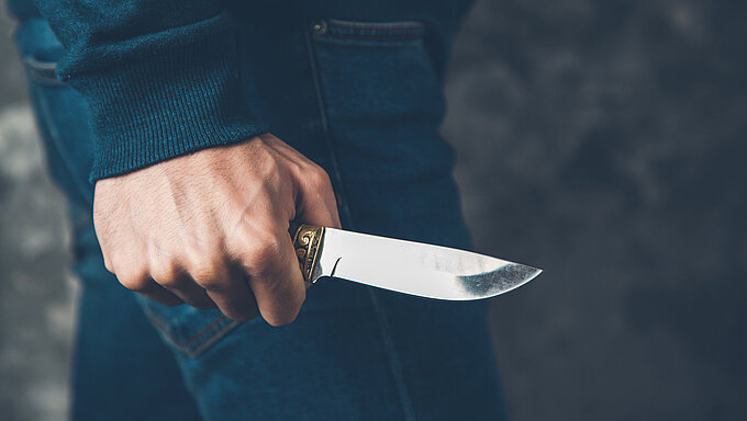 man hand holding knife on abstract background
